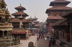 Pagodas de varios pisos y el paso de la gente en una plaza durbar