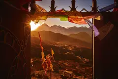 Valle al amanecer visto desde un portal con banderas de plegaria