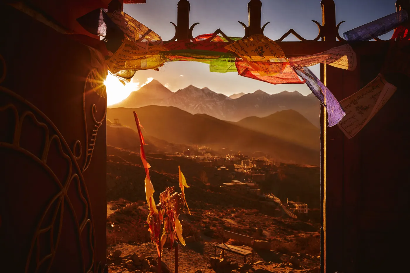 Valle al amanecer visto desde un portal con banderas de plegaria