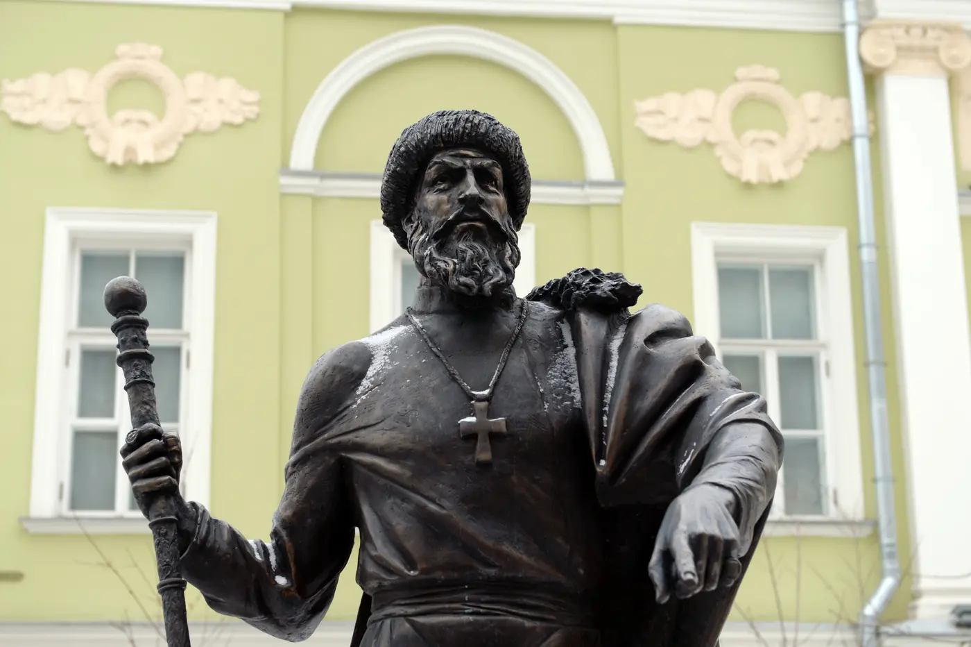 Estatua de bronce de un personaje histórico frente a una fachada de época